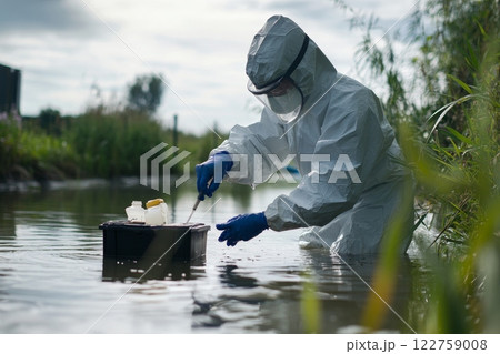 An Environmental Scientist is actively collecting water samples 122759008