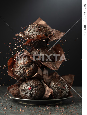 Dark chocolate muffins on a black background. 122760980