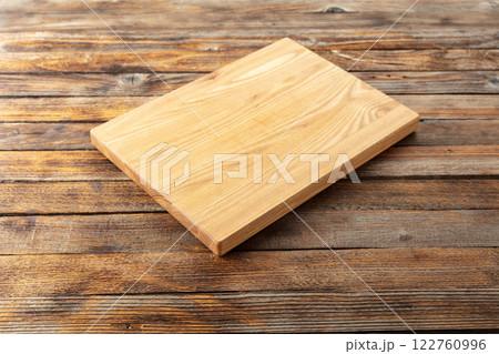 Cutting board on a old wooden kitchen table. 122760996