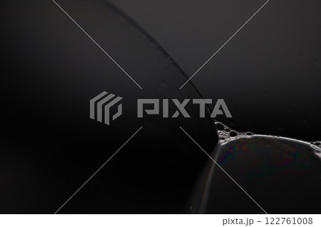 Transparent liquid surface, bubbles of thick liquid, silver reflection on dark background, gray colours, dark abstraction Transparent liquid surface, bubbles of thick liquid, silver reflection on dark background, gray colours, dark abstraction 122761008