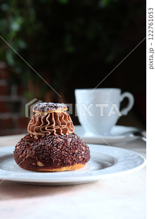 French Shu pastry with peach jam. Custard cake. A cup of coffee. A confectionery product. 122761053