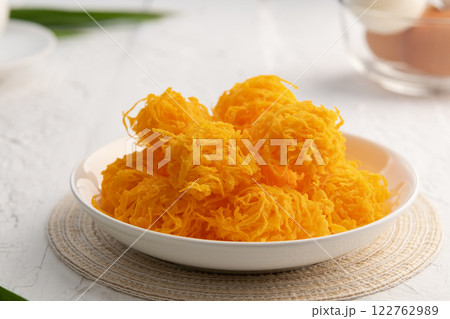 Close up Crispy Sweet egg floss or Golden Thread Egg,Shredded Egg Yolk Tart in white plate. Close up Crispy Sweet egg floss or Golden Thread Egg,Shredded Egg Yolk Tart in white plate. 122762989