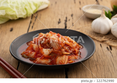 Close up Napa cabbage kimchi topped with white sesame seed in black plate,Korean fermented side dish food. Close up Napa cabbage kimchi topped with white sesame seed in black plate,Korean fermented side dish food. 122762990