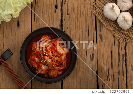 Napa cabbage kimchi topped with white sesame seed in black plate,Korean fermented side dish food.Top view with copy space. Napa cabbage kimchi topped with white sesame seed in black plate,Korean fermented side dish food.Top view with copy space. 122762991