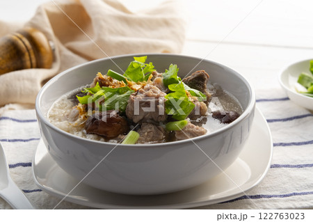 Pork Porridge.Boiled rice with Pork Baby Back Ribs or pork cartilage with shitake mushroom in white bowl.Asian breakfast style Pork Porridge.Boiled rice with Pork Baby Back Ribs or pork cartilage with shitake mushroom in white bowl.Asian breakfast style 122763023