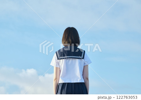青空と海を背景に立つ女子高校生 122763053