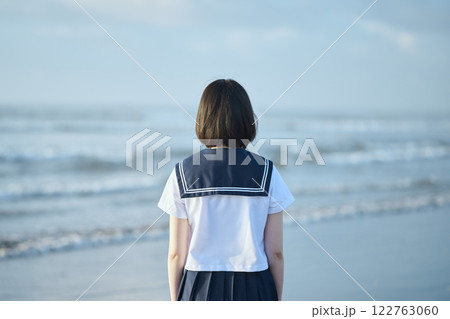 青空と海を背景に立つ女子高校生 122763060