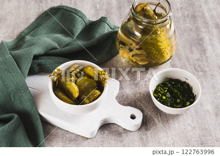 Pieces of pickled cucumbers with dill in a bowl on the table Pieces of pickled cucumbers with dill in a bowl on the table 122763996