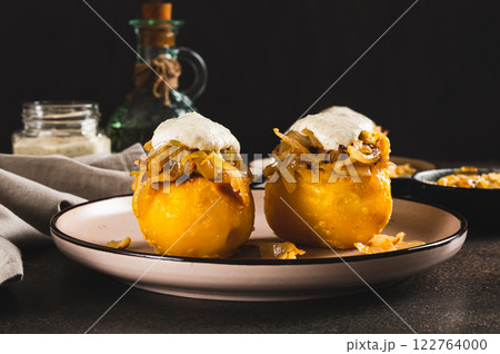 Baked potato with fried onions and ranch dressing on a plate on the table 122764000