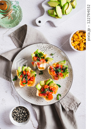 Poke bowls in pita bread with salmon and avocado on a plate top and vertical view Poke bowls in pita bread with salmon and avocado on a plate top and vertical view 122764032