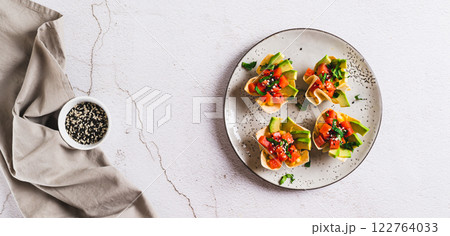 Poke bowls in pita bread with salmon and avocado on a plate top view web banner Poke bowls in pita bread with salmon and avocado on a plate top view web banner 122764033