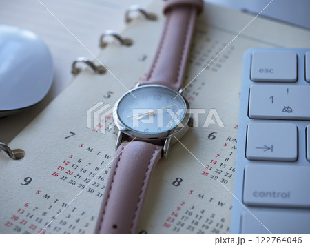 テーブルに置かれたカレンダーとキーボードと手帳と腕時計 122764046