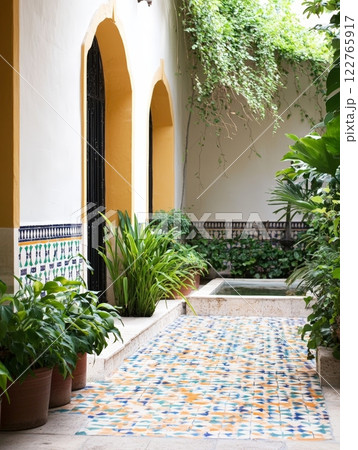 Serene tiled patio oasis with potted plants and elegant fountain for tranquil outdoor spaces 122765917