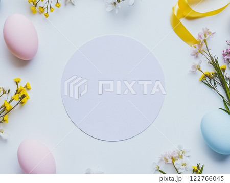 Easter background with a place for text in the center. Colored eggs, spring flowers, satin ribbons. View from above. 122766045