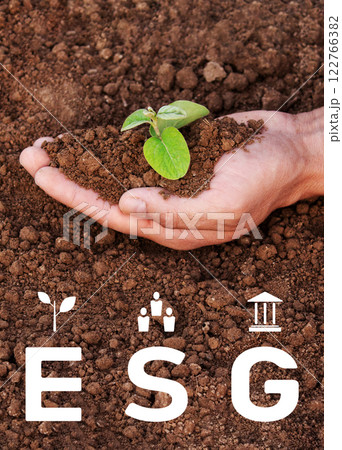 Environment social governance, a man is holding a small plant in his hand. The plant is in the hand and surrounded by earth. The concept of environmental problems Environment social governance, a man is holding a small plant in his hand. The plant is in the hand and surrounded by earth. The concept of environmental problems 122766382