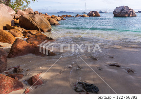 Shore water and wet sand of Anse Lazio beach on a sunny day 122766892