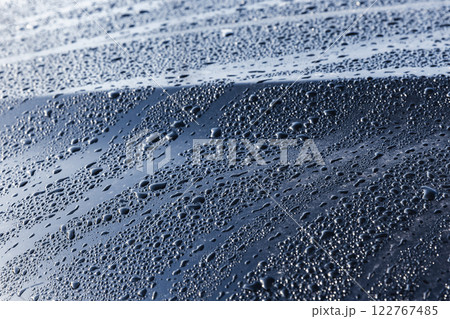 Abstract background. Water drops are on black car hood, close up 122767485