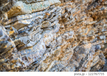 Layered rock texture in Budva, Montenegro. Sedimentary rocks with rugged surface of gray and brown. Natural formation of layers and cracks, geological structure. Layered rock texture in Budva, Montenegro. Sedimentary rocks with rugged surface of gray and brown. Natural formation of layers and cracks, geological structure. 122767735