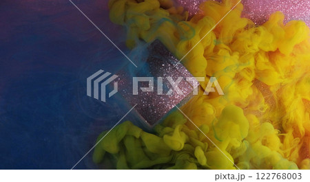 Blending colors. Paint spill. Bright blue yellow pink flow smoke glitter cube cloud ink texture on purple shimmering art background. 122768003