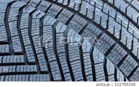 Deep sipes of car tires for driving in a deep snow detailed photo. Design of winter tire tread blocks and grooves 122768206