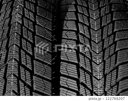 Directional design of the tread of car tires turned in different side of rotation. Textured pattern of directional tread blocks on a car tire 122768207