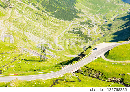 transfagarasan road winding uphill. outdoor adventure. travel destination in romania mountain landscape. sunny day in summer. view in to the valley. famous roadway 122768286