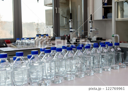 Laboratory equipment. Laboratory storage bottles with blue polypropylene cap on white table. 122769961