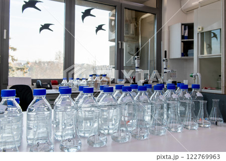 Laboratory equipment. Laboratory storage bottles with blue polypropylene cap on white table. Laboratory equipment. Laboratory storage bottles with blue polypropylene cap on white table. 122769963