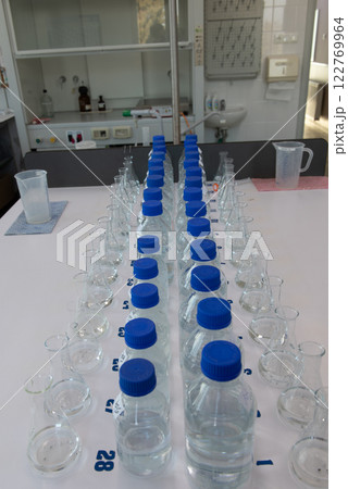 Laboratory equipment. Laboratory storage bottles with blue polypropylene cap on white table. 122769964