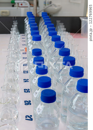 Laboratory equipment. Laboratory storage bottles with blue polypropylene cap on white table. Laboratory equipment. Laboratory storage bottles with blue polypropylene cap on white table. 122769965