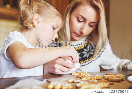 Mom and daughter decorate the Christmas cookie with white sugar Mom and daughter decorate the Christmas cookie with white sugar 122770048