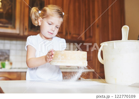 A happy girl wears a dough. Baby make dinner in chef suit A happy girl wears a dough. Baby make dinner in chef suit 122770109