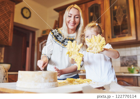 Happy daughter and mom in the kitchen bake cookies 122770114