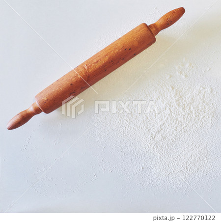 Wooden rolling pin with white wheat flour on the table. top view 122770122