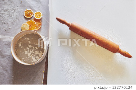 Wooden rolling pin with white wheat flour on the table. top view 122770124