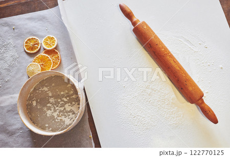 Wooden rolling pin with white wheat flour on the table. top view 122770125