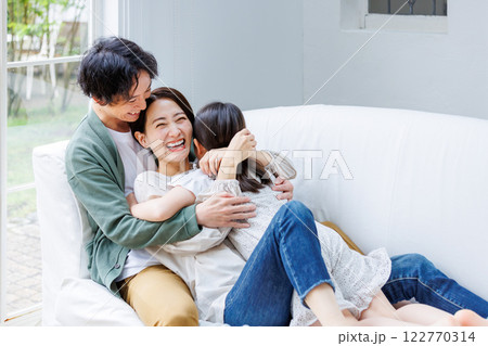 リビングのソファに座る笑顔の親子 122770314