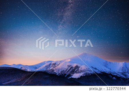 Beautiful winter landscape in the Carpathian mountains. Vibrant night sky with stars and nebula and galaxy. Deep sky astrophoto 122770344