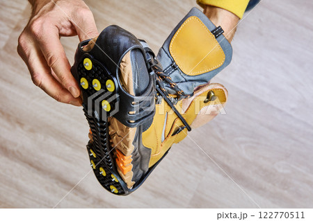 Ice traction devices with rubber straps and metal spikes ensure safety and stability in winter conditions. 122770511