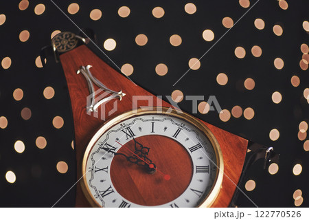 Happy New Year at midnight 2018, Old wooden clock with holiday lights Happy New Year at midnight 2018, Old wooden clock with holiday lights 122770526