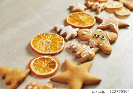Christmas gingerbread cookies and dried orange and spices on white table Christmas gingerbread cookies and dried orange and spices on white table 122770564