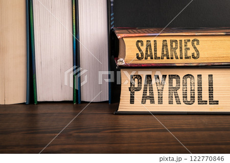 Payroll and Salaries Concept. Stack of books on a wooden shelf Payroll and Salaries Concept. Stack of books on a wooden shelf 122770846