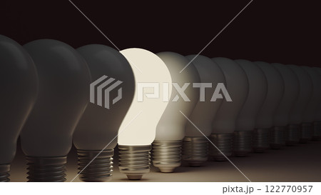 Light bulbs in a line, with one shining uniquely, representing an idea and career concept of standing out. 122770957