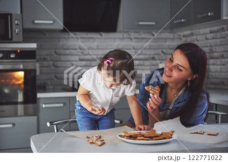 Mother bake with her daughter in the kitchen. 122771022
