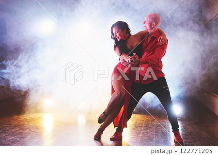 Skillful dancers performing in the dark room under the concert light and smoke. Sensual couple performing an artistic and emotional contemporary dance 122771205