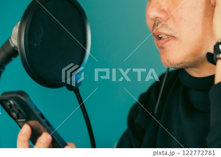 スマホで歌詞を見ながら歌う中高年の男性　顔無し 122772781