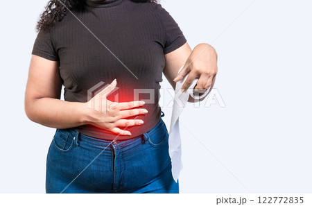 Woman with stomach problems holding roll of paper. Person with stomach pain holding paper roll isolated Woman with stomach problems holding roll of paper. Person with stomach pain holding paper roll isolated 122772835