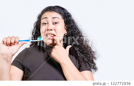 Young woman with gingivitis holding toothbrush isolated. Girl suffering from gum pain holding toothbrush. People holding toothbrush with gum problem Young woman with gingivitis holding toothbrush isolated. Girl suffering from gum pain holding toothbrush. People holding toothbrush with gum problem 122772836