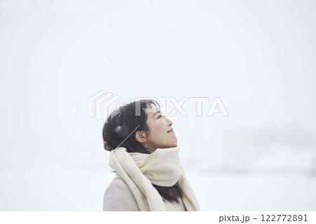 冬の雪国に佇むマフラーを巻いた日本人女性 122772891