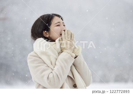 冬の雪国に佇むマフラーを巻いた日本人女性 122772893